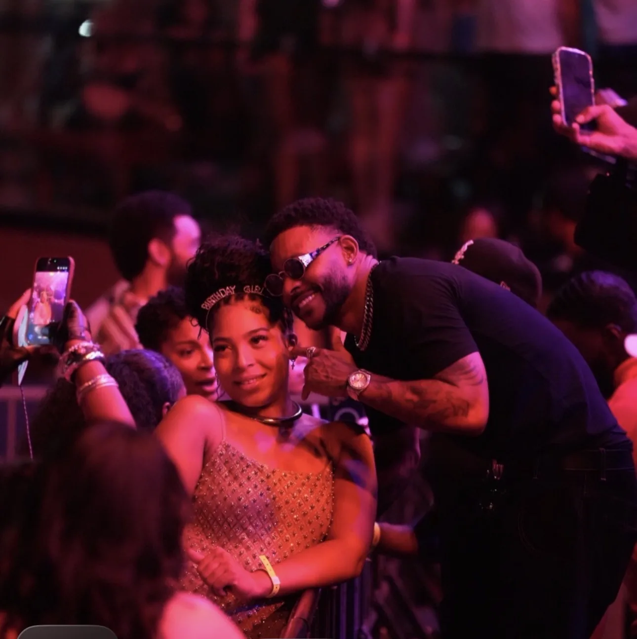 Two guests posing for a photo among the crowd